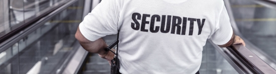 Person with security on back of shirt riding an escalator